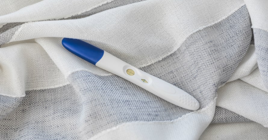 pregnancy-test-on-a-bed