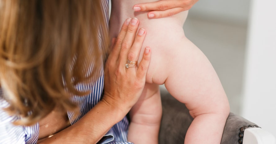 baby-s-buttock-feet-mother-s-hands-mother-holds-newborn