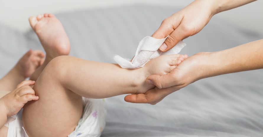 mother uses baby wipes on her baby