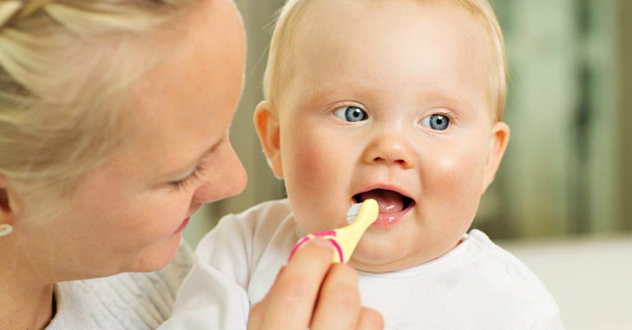 mom brushing her child’s teeth