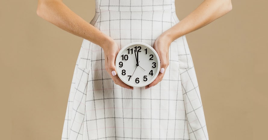 lady holding clock in front of her stomach