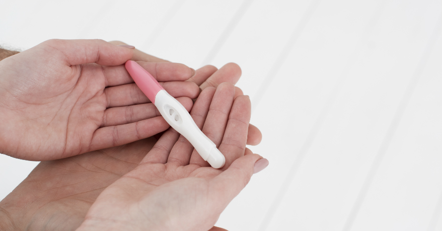 couple holding positive pregnancy test in their hads