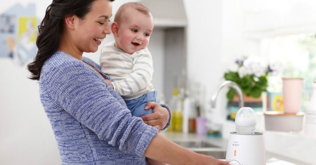 mother holding her baby near the table